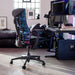 A Herman Miller X Logitech Embody Gaming Chair in blue Cyan as part of a gaming setup.